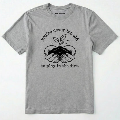 Sport Grey t-shirt with black graphic and text 'you're never too old to play in the dirt' on a white background
