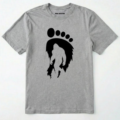 Sport Grey bigfoot t-shirt with cryptid-themed footprint graphic and sasquatch silhouette on a white background.