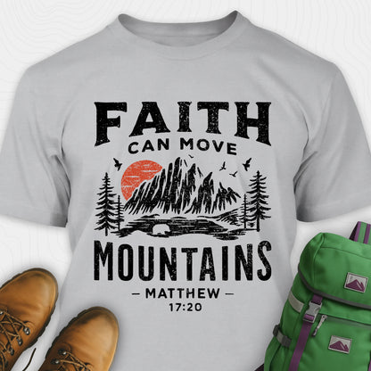 Grey bible verse t-shirt with 'Faith can move mountains' design and hiking boots and backpack on a white background