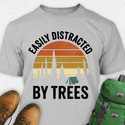 Gray funny tree shirt with "easily distracted by trees" text and retro sunset design