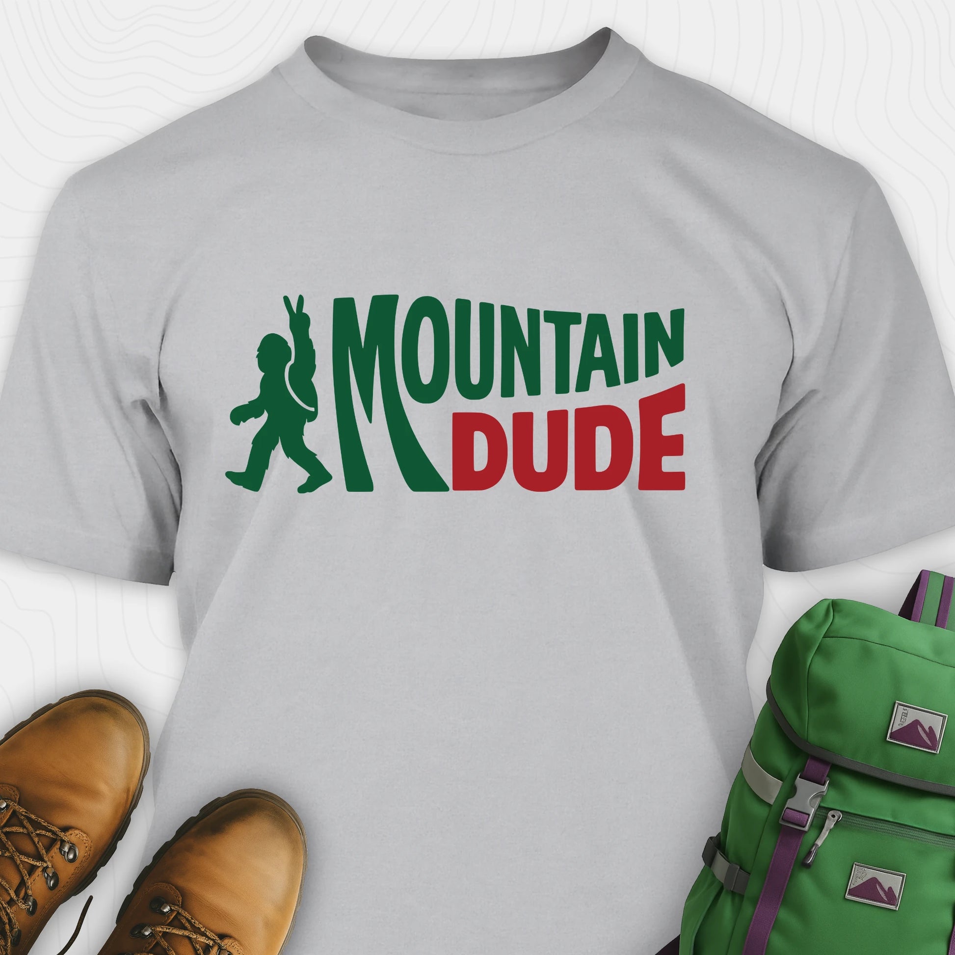 Grey Mountain Dude shirt with green and red text and Bigfoot graphic.