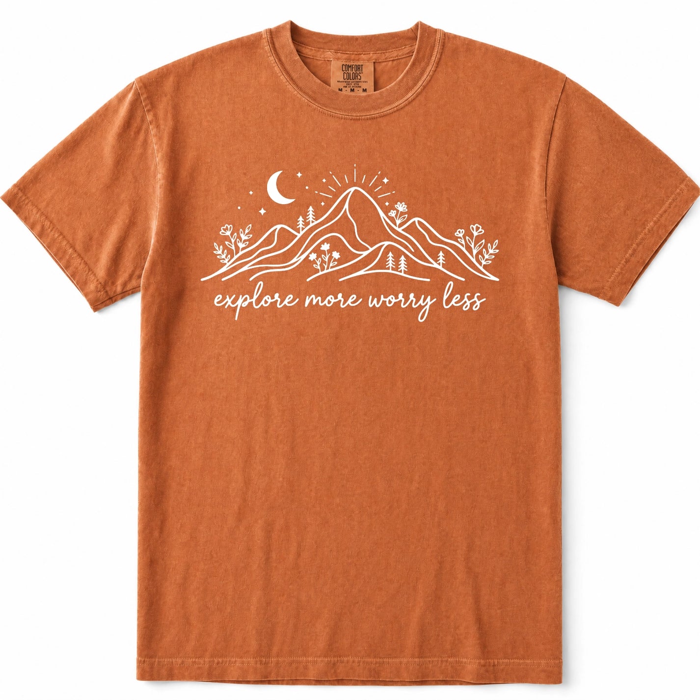 Yam burnt orange crewneck t-shirt with a white graphic of mountains, a crescent moon, and the text 'explore more worry less' printed on the chest, displayed flat against a white background.