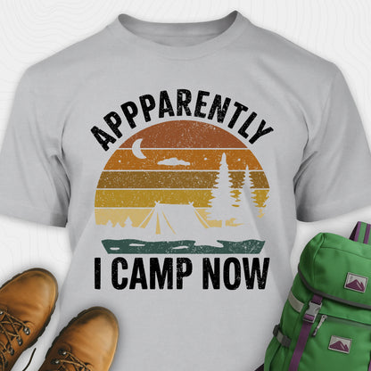 Sport Grey t-shirt with “Apparently I Camp Now” in white text and a vintage sunset camping scene with tent, trees, and moon.