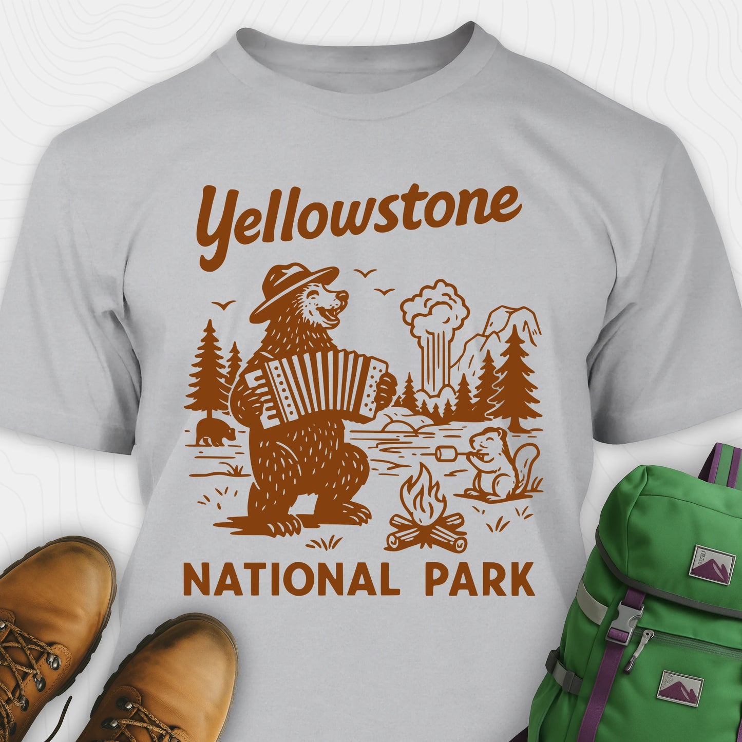 Sport Grey t-shirt with a brown bear playing an accordion and “Yellowstone National Park” text, styled with hiking boots and a green backpack.