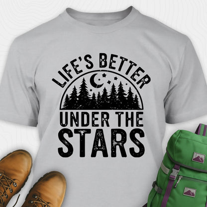 Sport grey Life's Better Under the Stars t-shirt with forest and moon graphic, paired with brown boots and a green backpack on a white background.