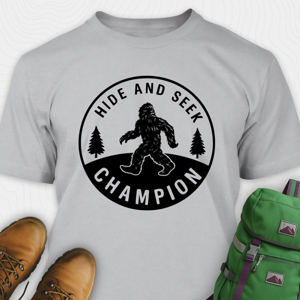 Grey bigfoot hide and seek champion shirt with forest emblem