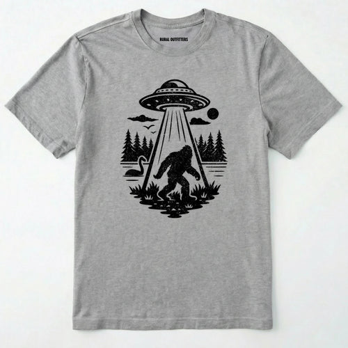 Sport Grey monster shirt with Bigfoot, a forest scene, and a UFO beam graphic on a white background.