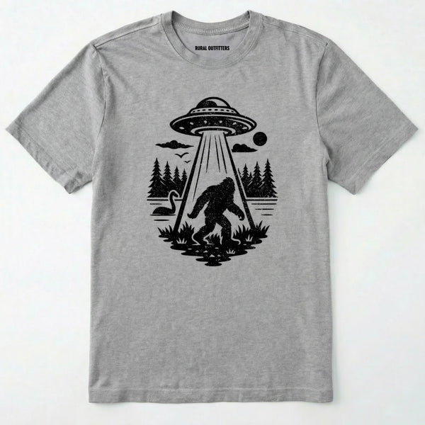 Sport Grey monster shirt with Bigfoot, a forest scene, and a UFO beam graphic on a white background.