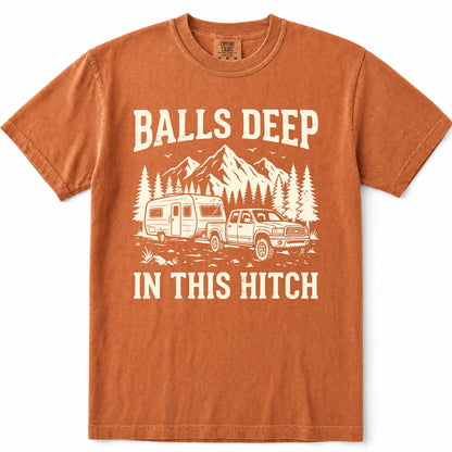 Yam rust-orange crewneck t-shirt with a cream-colored graphic print featuring a pickup truck towing a camper trailer, pine trees, and mountains, with the text 'BALLS DEEP IN THIS HITCH'.