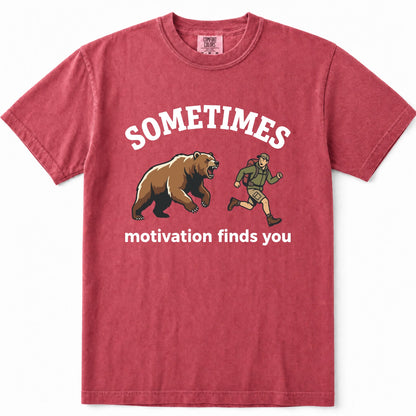 Crimson crewneck t-shirt with a graphic print showing a brown grizzly bear and a hiker, with the text 'SOMETIMES motivation finds you' in white.