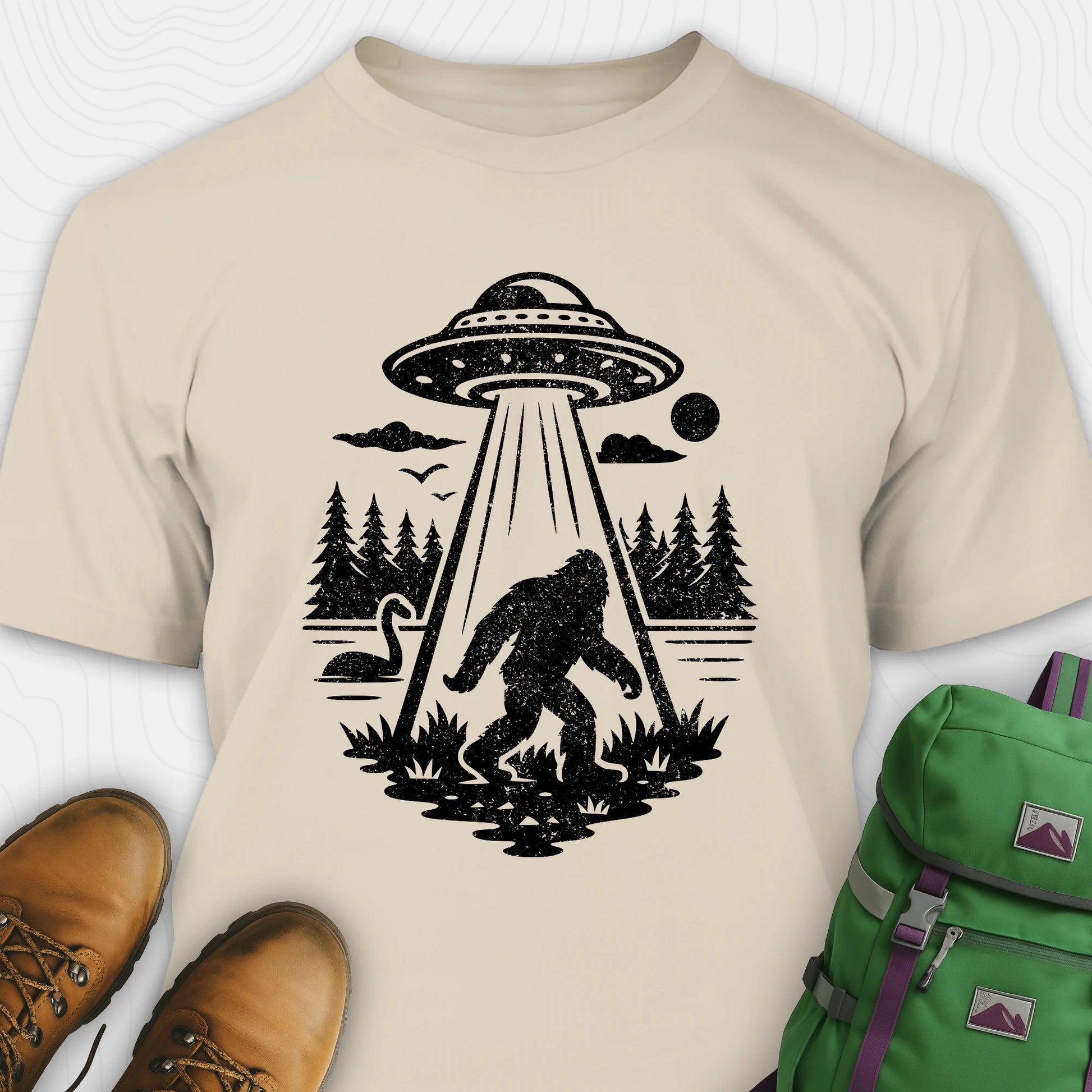 Sand monster shirt with bigfoot, forest scene, and ufo beam graphic
