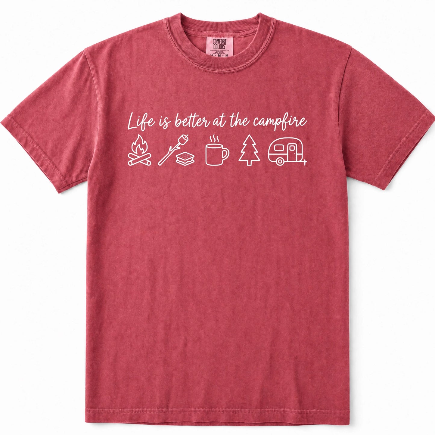 Crimson short-sleeve crewneck t-shirt in a washed, heathered red color, featuring a white graphic print on the chest that reads 'Life is better at the campfire' above simple white icons of a campfire, marshmallow, mug, pine tree, and camper trailer.