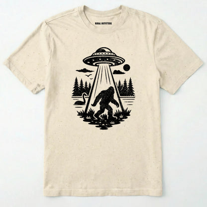 Natural monster shirt with Bigfoot, a forest scene, and a UFO beam graphic on a white background.
