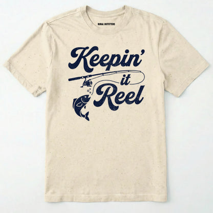 Natural t-shirt with 'keepin' it reel' text and fishing graphic on a white background