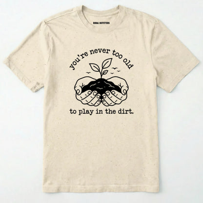 Natural t-shirt with a graphic and text 'you're never too old to play in the dirt' on a white background