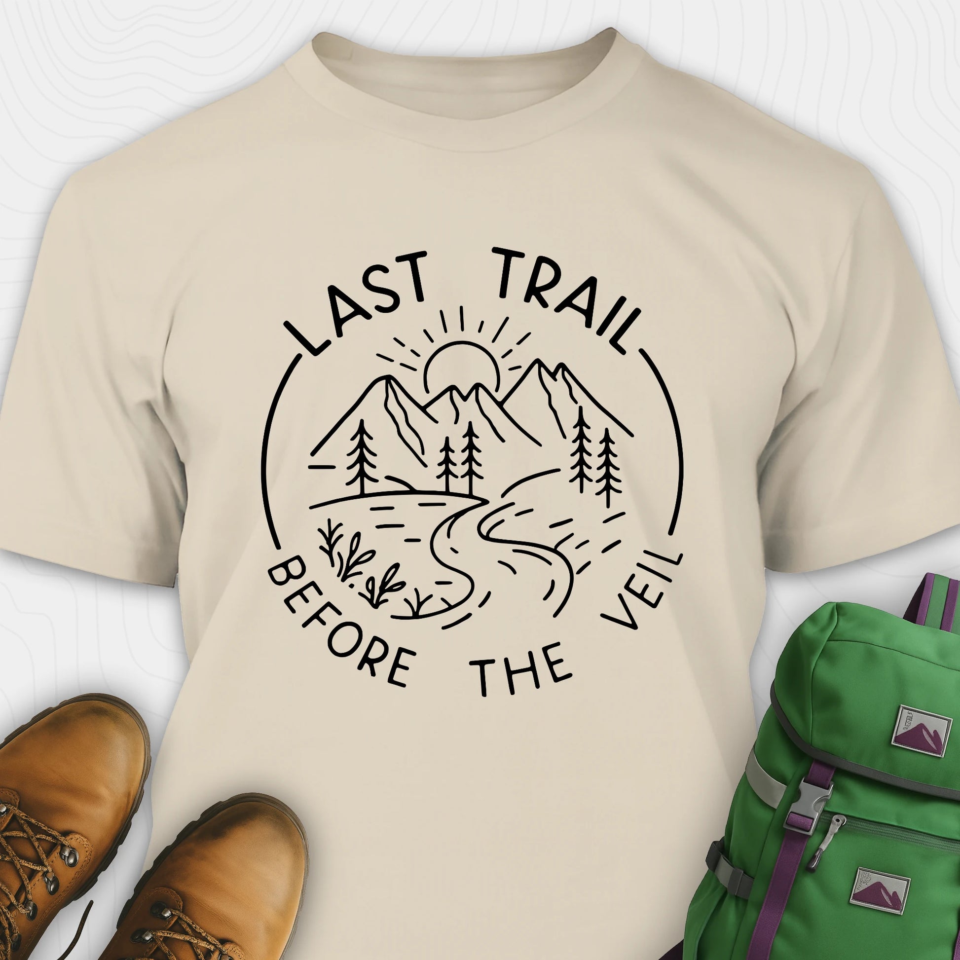 Sand nature-themed Last Trail Before the Veil shirt with line-art mountain scene.