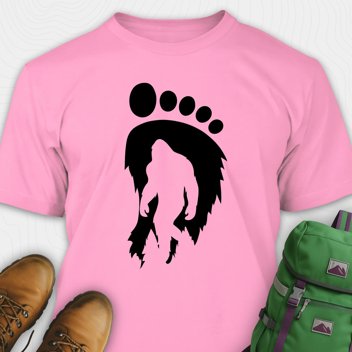 Pink bigfoot t-shirt with cryptid themed footprint graphic and sasquatch silhouette