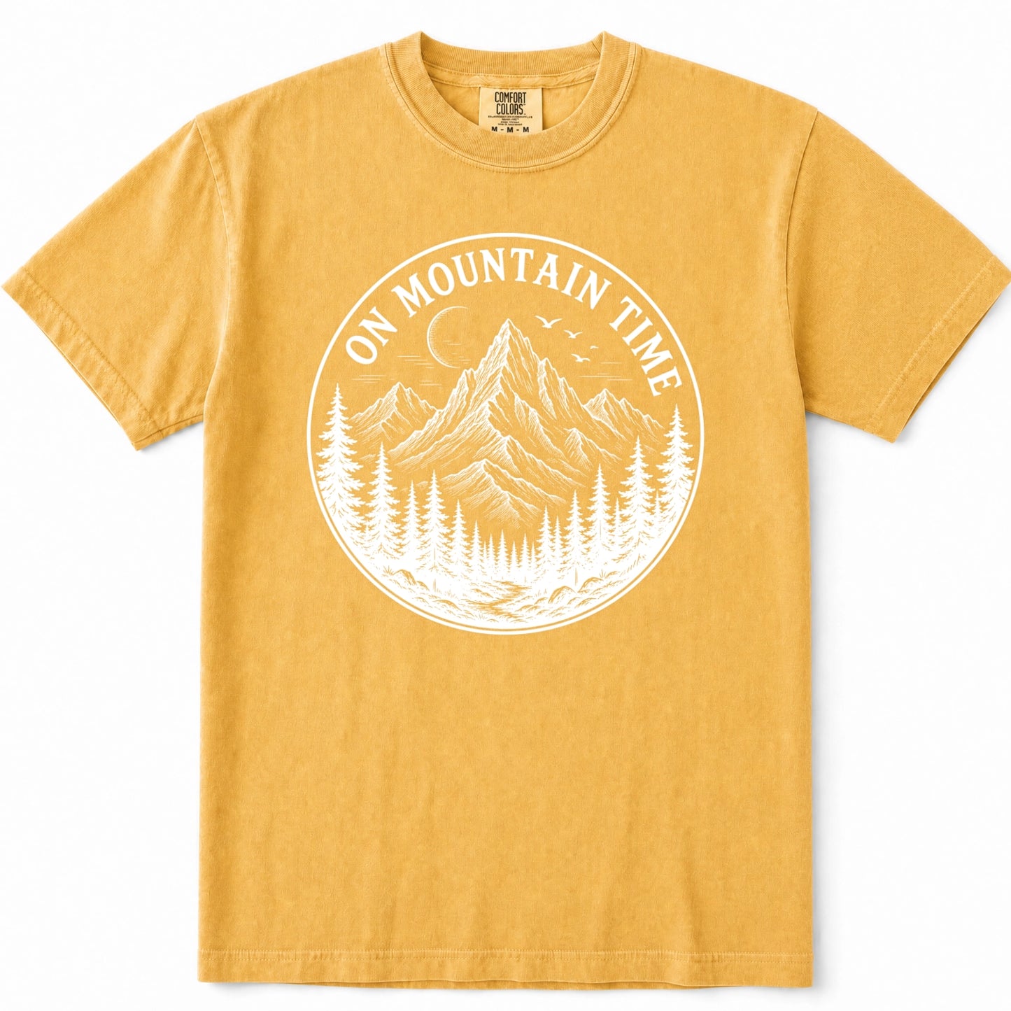 Mustard yellow short-sleeve t-shirt with a white circular graphic on the chest depicting a mountain, pine trees, and the text 'ON MOUNTAIN TIME'.