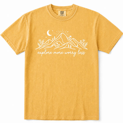 Mustard short-sleeve crewneck t-shirt with a white graphic of mountains, a crescent moon, and the text 'explore more worry less' printed on the front.