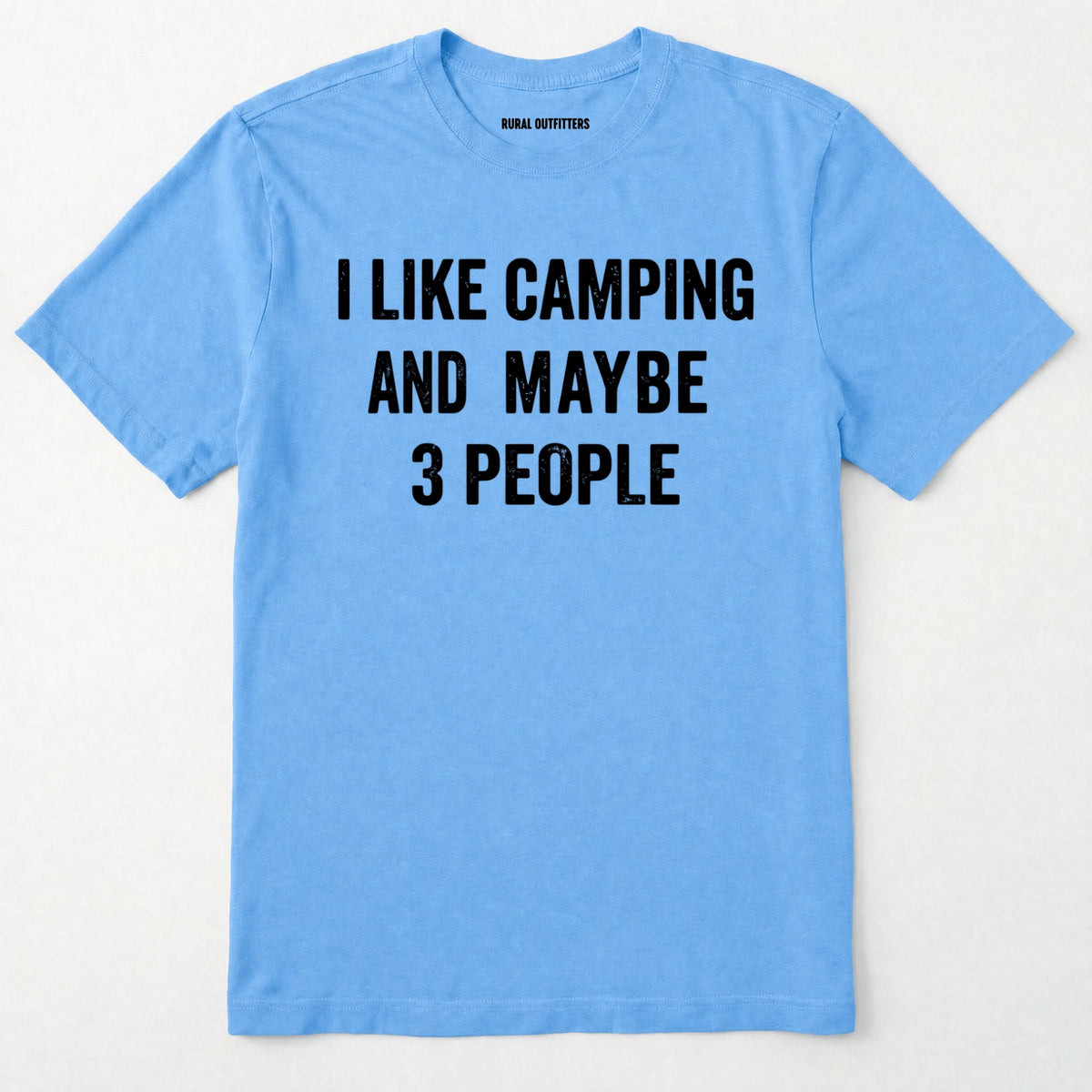 Carolina Blue short-sleeve t-shirt with bold black text reading 'I LIKE CAMPING AND MAYBE 3 PEOPLE' across the chest, laid flat against a light off-white background.