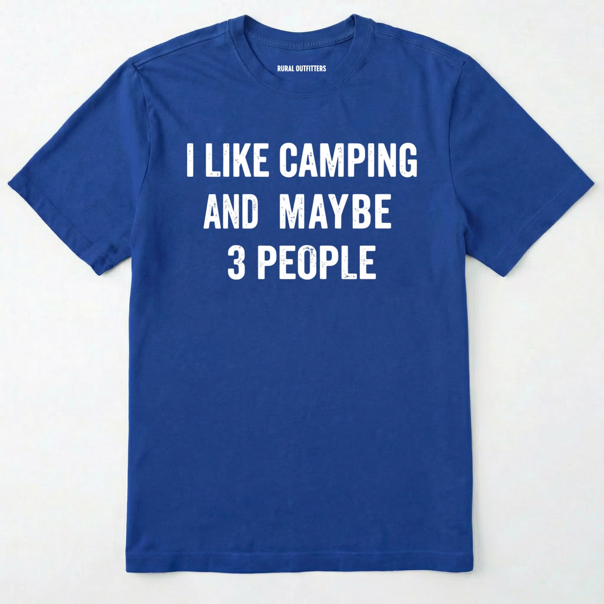 Royal blue short-sleeve t-shirt with bold white text reading 'I LIKE CAMPING AND MAYBE 3 PEOPLE' across the chest, laid flat against a light off-white background.