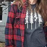 Person wearing a red plaid shirt over a graphic t-shirt with trees.